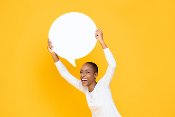 Cheerful happy young African American woman smiling and holding speech bubble with empty space for...