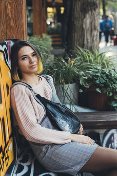 Beautiful young wonam sits at summer outdoor cafe.