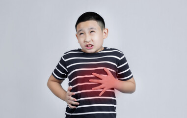 Asian boys studio portrait on gray background with hand on stomach because nausea, painful disease feeling unwell. Ache concept.