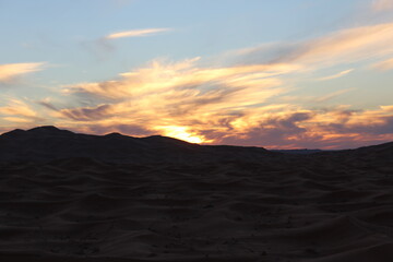 The sunset behind the large valleys in the desert