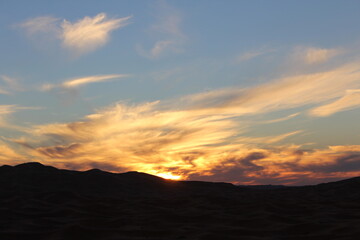 The sunset behind the large valleys in the desert