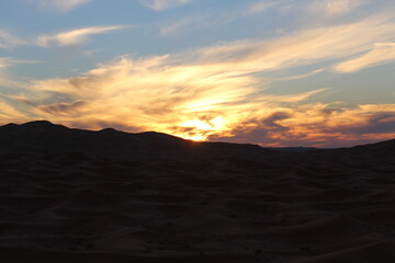 The sunset behind the large valleys in the desert