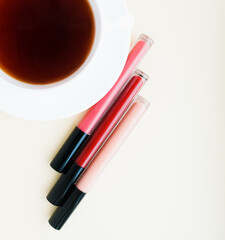 liquid lipstick in a tube on a light background and a cup of tea