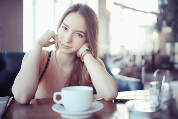girl spring cafe portrait, happy young model posing with a cup of coffee, spring look