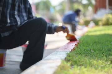 Asian worker painting no parking sign