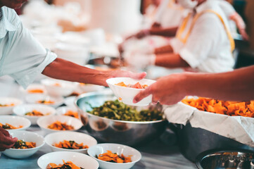 The hands of the poor receive food that volunteers share to alleviate hunger: the concept of donating food to the poor
