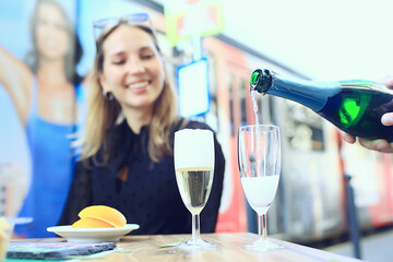 glasses of toast chin chin, hands with glasses of white wine in a street cafe