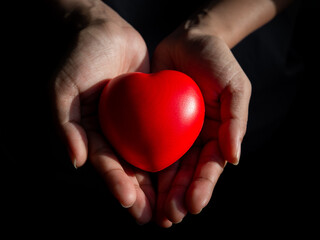 Red heart. Big red heart ball in hand on dark background.