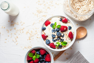 Breakfast, oatmeal with blueberry and raspberry on white bowl in the morning.