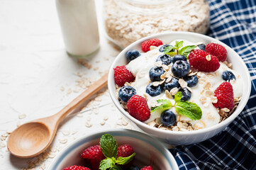 Breakfast, oatmeal with blueberry and raspberry on white bowl in the morning.