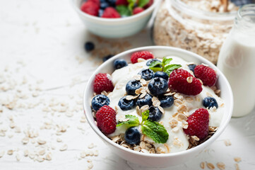 Breakfast, oatmeal with blueberry and raspberry on white bowl in the morning.