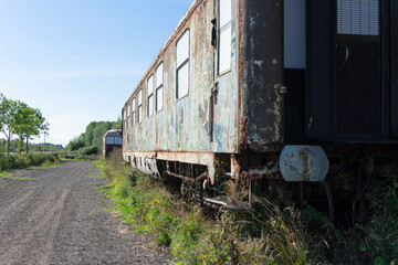 Fototapeta na wymiar Old abandoned and rusty train wagon where the paint is already peeling off
