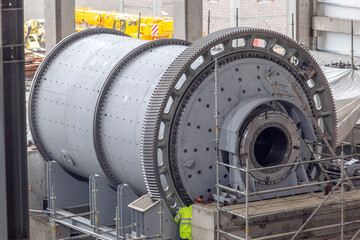 Close up view of the large ball and sag mill in the mine plant. A typical type of fine grinder is the ball mill. A slightly inclined or horizontal rotating cylinder is partially filled with balls. © Funtay
