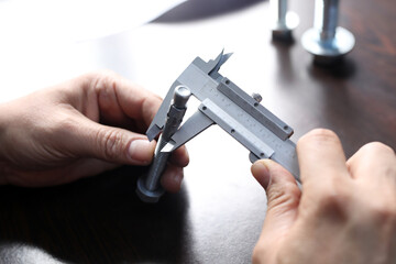 Inspector is measuring diameter of the bolts with a manual verniel caliper micrometer gauge. The Vernier caliper is an extremely precise measuring instrument; the reading error is 1/20 mm = 0.05 mm.