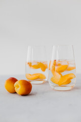 Homemade lemonade made from fruits and berries. Glasses with slices of apricots. Freshen up in the summer
