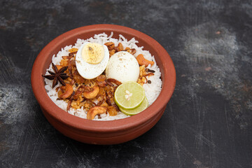 Egg Biryani or Indian anda rice - Basmati rice cooked with masala roasted eggs and spices and served with yogurt popular rice food in India