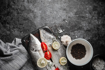 Fresh raw sea bass fish on wooden cutting board, cooking concept.