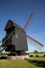 Old black mill with fields around it