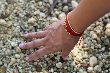 woman with bracelet touching some rocks
