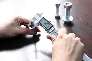 Worker is measuring to the diameter of the small pipe with a digital vernier caliper micrometer. Micrometer, sometimes known as a micrometer screw gauge, is a device incorporating a calibrated screw.