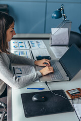 Business woman sitting at her desk working on laptop in office.