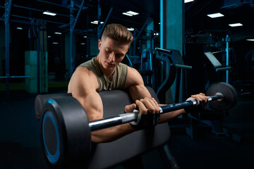 Fototapeta na wymiar Bodybuilder training biceps with barbell.