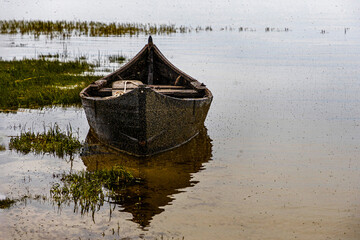 old boat stands in calm waters