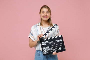 Smiling young blonde woman girl in casual striped shirt posing isolated on pink background studio...