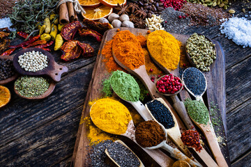 Many multi colored spices and dried fruits on the table