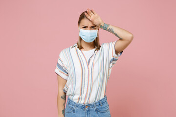 Sick young woman in casual striped shirt sterile face mask isolated on pink background. Epidemic...