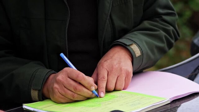 Forester Writing Sheet of Paper From Front Close Up Detail