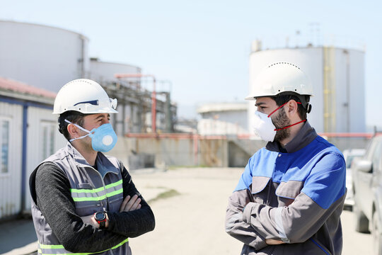 Workers are talking with protective masks for coronavirus (covid-19) epidemic in the construction field. In humans, coronaviruses cause respiratory tract infections that can range from mild to lethal.