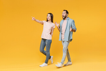 Excited young couple two friends guy girl in pastel blue casual clothes posing isolated on yellow...