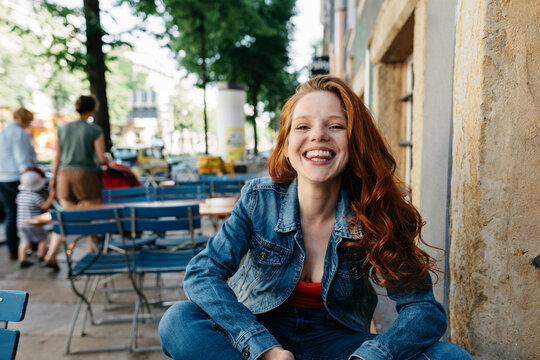 Cute young redhead woman with happy grin