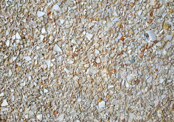 Facade lined with small beige stones and broken ceramics