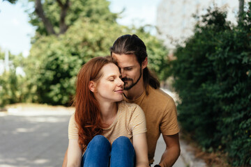Naklejka premium Loving young couple nuzzling outdoors