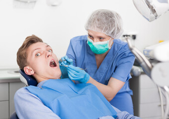 Young man on dental checkup in modern dentist office