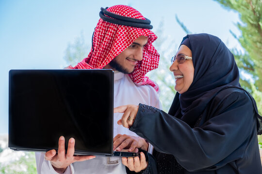 Muslim Couple Using Laptop And Discussing Business