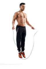 Shirtless bodybuilder jumping using rope.