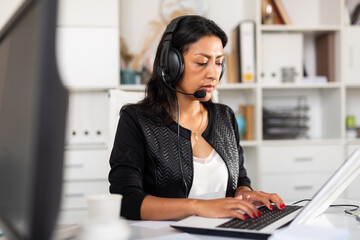 Female customer support phone operator with headphones during work