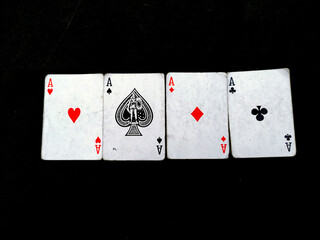 Set of four aces playing cards suits. Winning poker hand isolated on black background