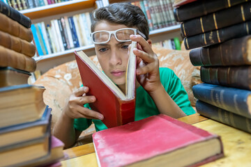 Muslim arabic boy reading book in library