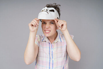 Portrait of young woman holding white mask. Theater concept