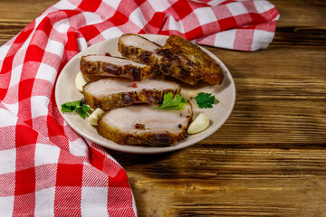 Baked pork belly in a plate on wooden table