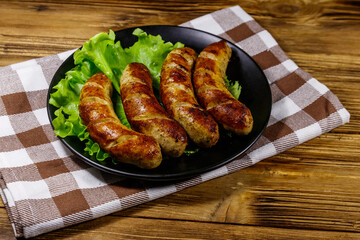 Tasty grilled sausages on a wooden table