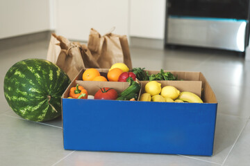 Contactless Grocery delivery. Fresh fruits and vegetables in recyclable paper bags and box. Grocery shopping. Local farm products delivered to home kitchen