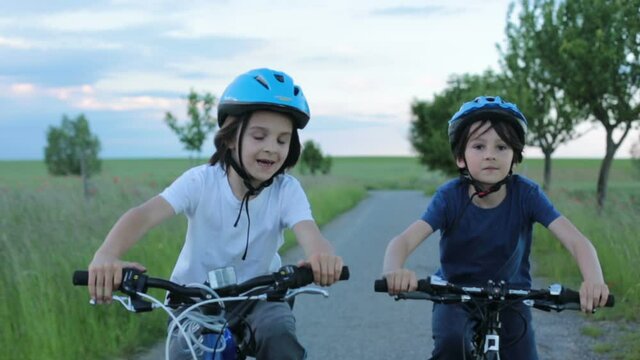 Children, boys, riding bikes  together summer time on a rainy day