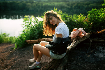 A girl in a delicate blue dress walks along a path on the top of a mountain near the river