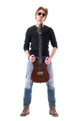 Cocky self assured young rocker guitarist posing and holding electric guitar with sunglasses. Full body length isolated on white background. 