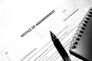 The notice of abandonment document. Document old style black and white. Paper and pen on the table.